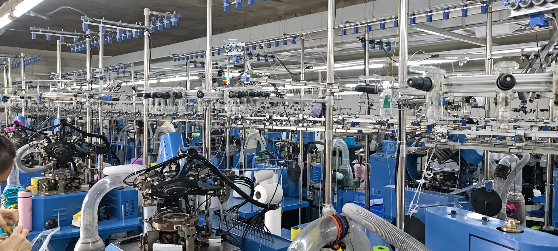 Textile knitting machines with overhead yarn-feed frames