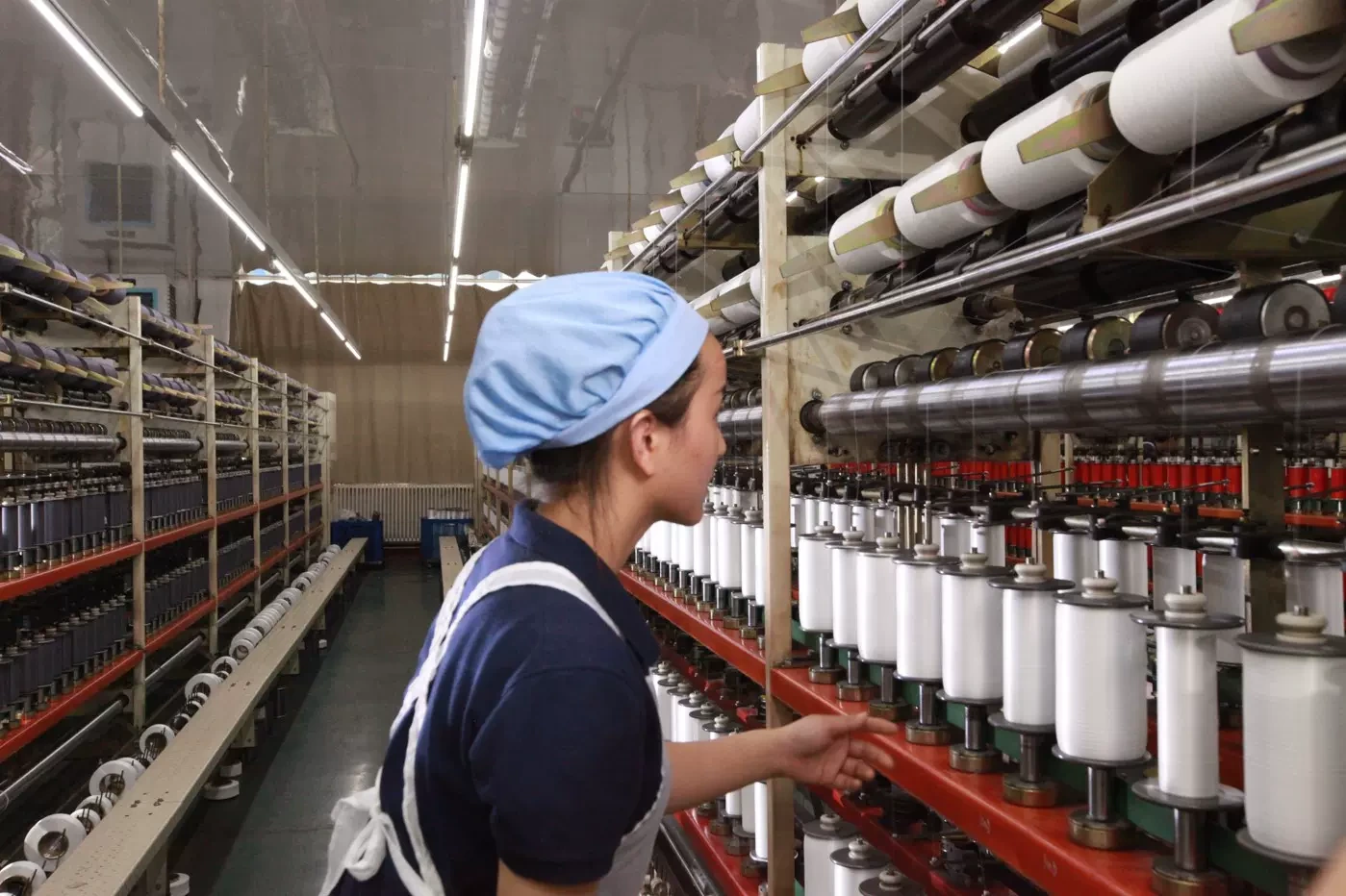 Operator working beside yarn-winding equipment