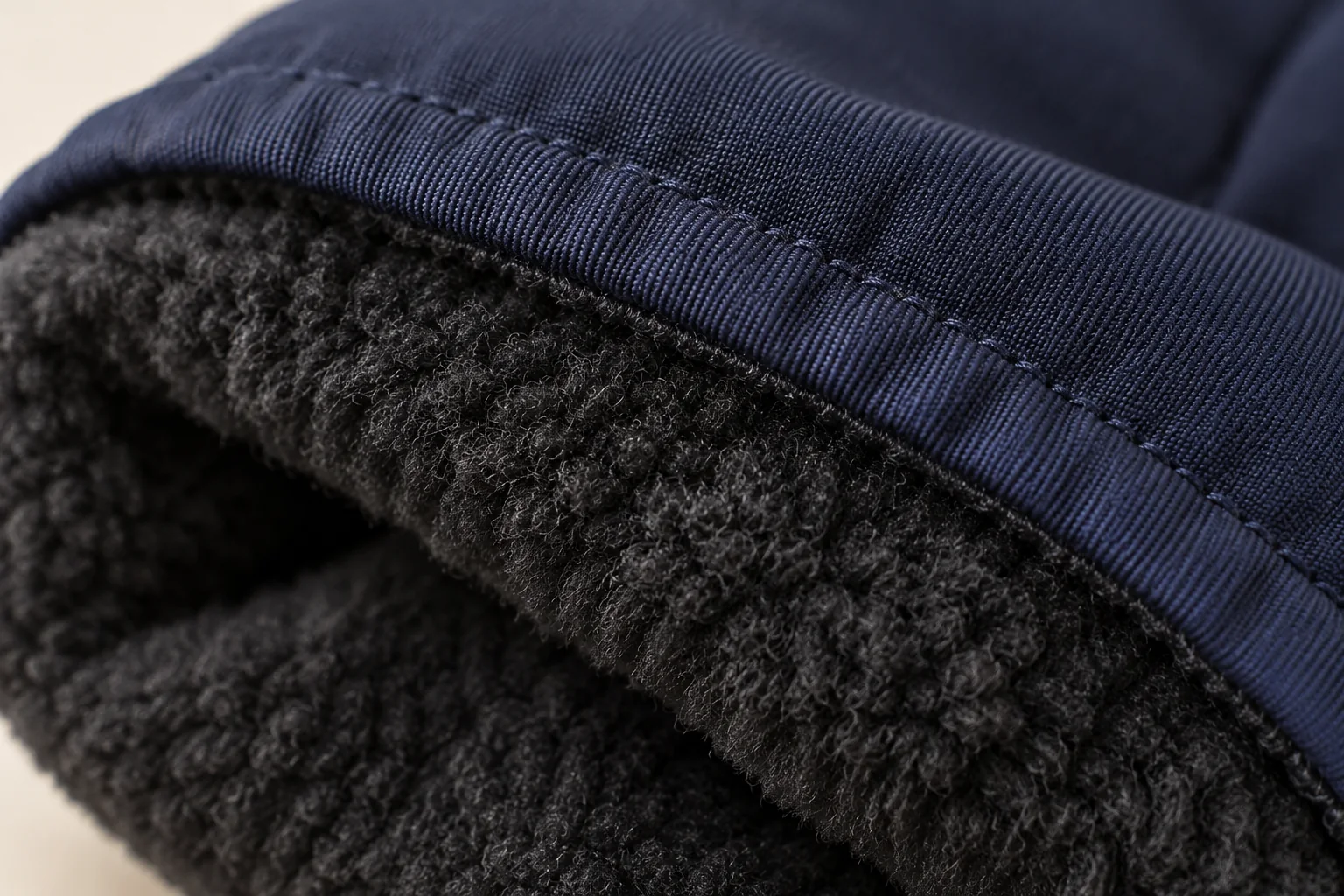 Navy winter glove: macro dark fleece lining attached beneath navy woven cuff edge.
