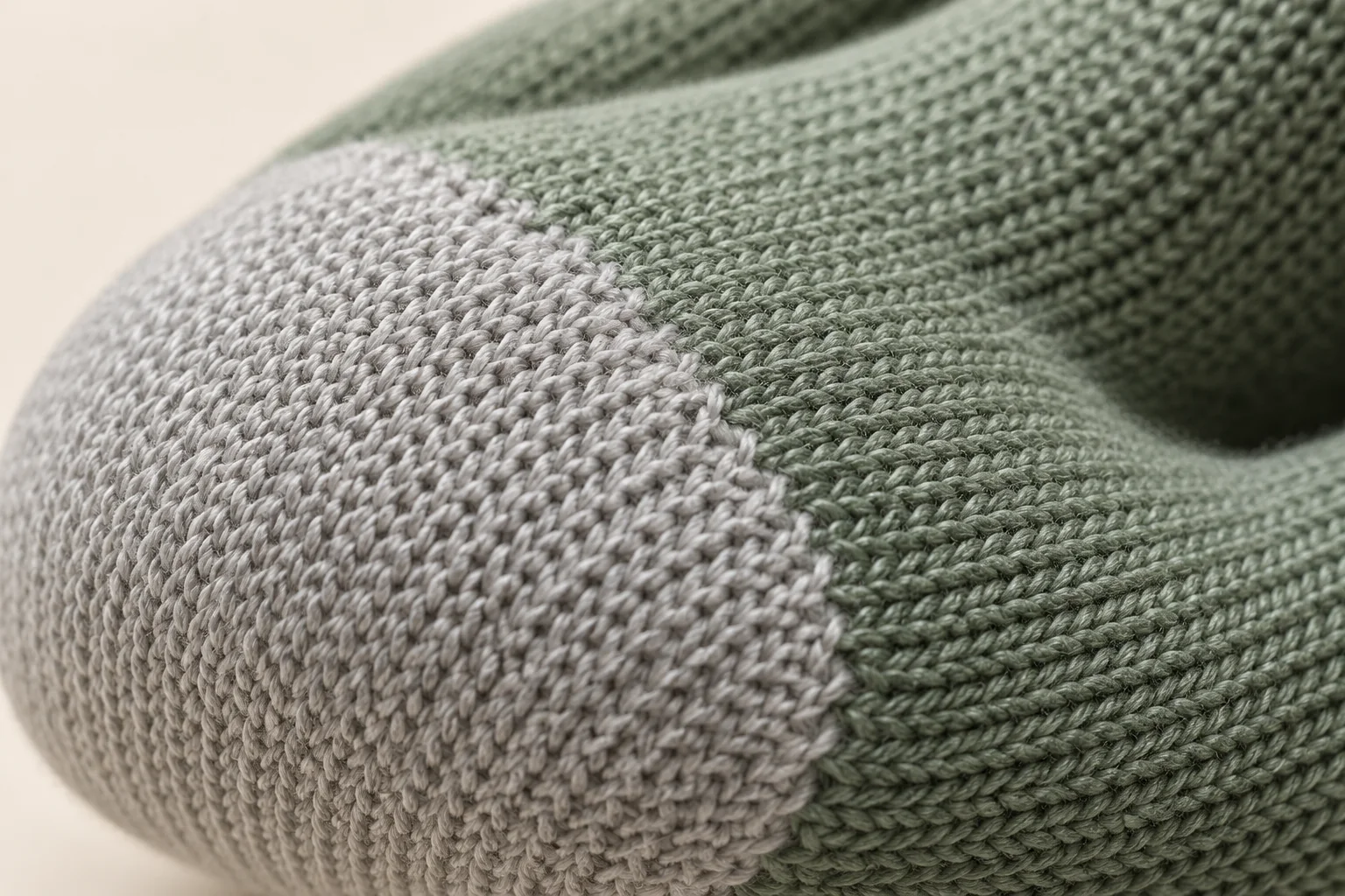Sage-green fine-knit glove: macro boundary of light gray integrated knitted contact zone and sage finger knit.